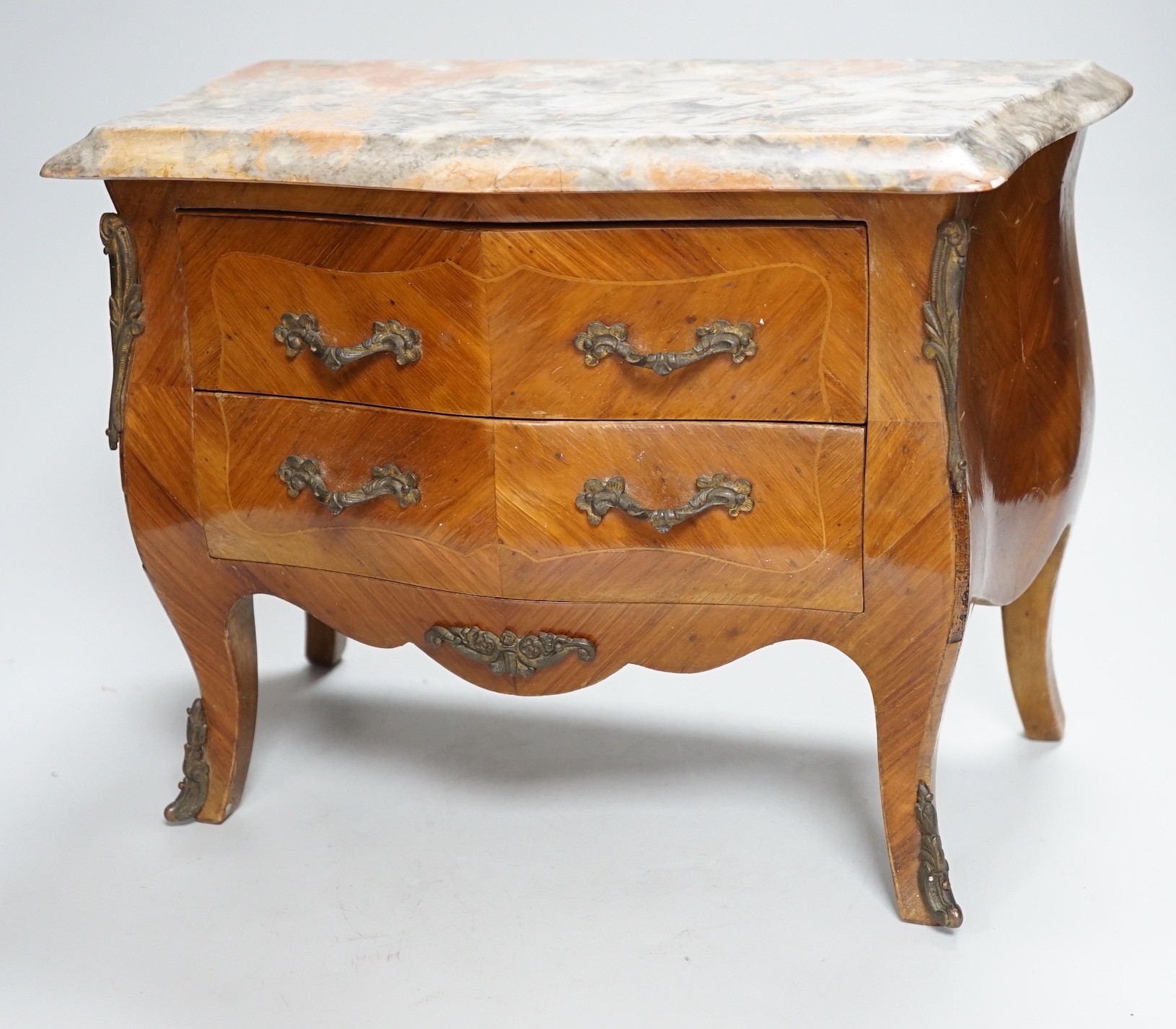 An Apprentice piece: Louis XV style miniature bowfronted French chest, with gilt mounts and pink and grey marble top. 27cm tall, 36cm wide, 17cm deep